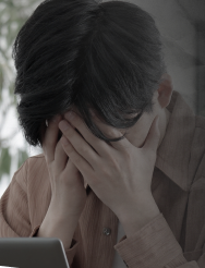 頭を抱えて悩む男性